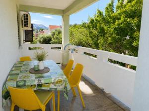 a dining room with a table and chairs on a balcony at Apartments Mohar II in Baška