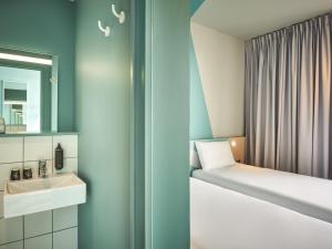 a small bathroom with a bed and a sink at ibis budget Nancy Laxou in Nancy