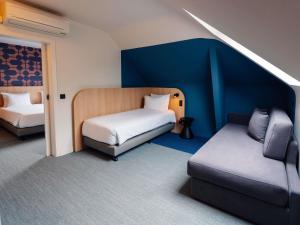 a room with two beds and a couch in it at Ibis Styles Charleroi Airport Aero 44 in Charleroi +114 photos