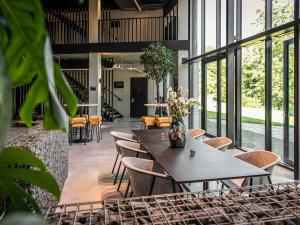 a dining room with a table and chairs and windows at Hotel Valkenburg by Mercure - Next to Shimano Experience Center in Valkenburg