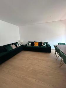 a living room with a black couch with pillows at Casa Rosarinho in Faro