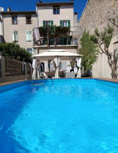 a large blue swimming pool next to a building at Maison chez Marthe in Le Muy
