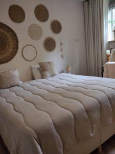a bedroom with a large bed with plates on the wall at HotelPension van Ewijcksluis in Anna Paulowna