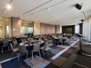 a banquet hall with tables and chairs and a podium at Novotel Melbourne Preston in Melbourne