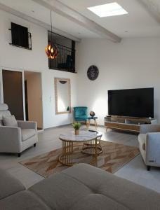 a living room with a tv and a couch and a table at Maison chez Marthe in Le Muy