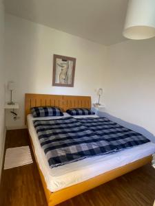 a bedroom with a bed with a blue and black checkered blanket at Ferienwohnung Meding am See in Schondorf am Ammersee