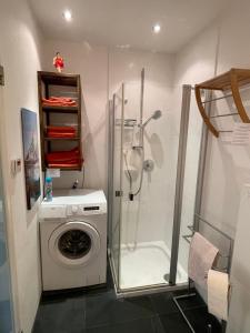 a bathroom with a washing machine and a shower at Ferienwohnung Meding am See in Schondorf am Ammersee +8 photos