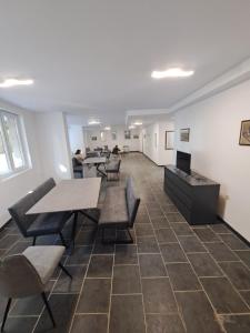 an empty office with tables and chairs and people in the background at Limani Guest house in Sozopol