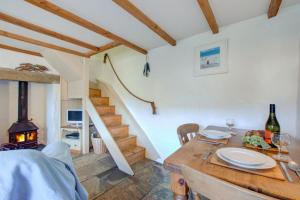 a dining room with a table and a wood stove at 1 Bed in Ruan Minor oc-rencot in Ruan Minor