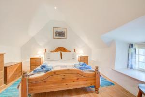 a bedroom with a wooden bed with blue towels on it at 1 Bed in Ruan Minor oc-rencot in Ruan Minor
