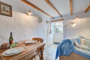 a dining room with a table and a couch at 1 Bed in Ruan Minor oc-rencot in Ruan Minor +5 photos