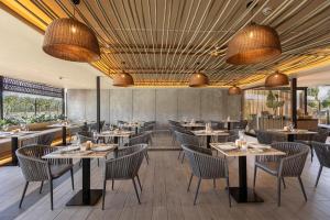 a restaurant with tables and chairs and large windows at Maspalomas Villas by Dunas - Adults Only in Maspalomas