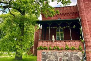a statue sitting on the window of a brick building at Herrenhaus Libnow in Murchin