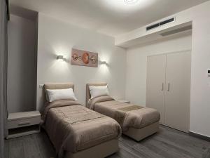 two beds in a small room with white walls at Residence Meraviglia in Schio