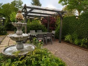 a fountain in a garden with a table and chairs at 5 Bed in Hundleby oc-o44769 in Spilsby