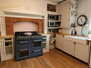 a kitchen with a stove and a brick fireplace at 5 Bed in Hundleby oc-o44769 in Spilsby