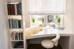 a white desk with a window and a white chair at Heidetraum - Modernes Ferienhaus in der Lüneburger Heide in Soltau +42 photos