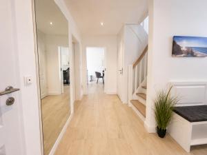 a hallway with white walls and a staircase in a house at Heidetraum - Modernes Ferienhaus in der Lüneburger Heide in Soltau