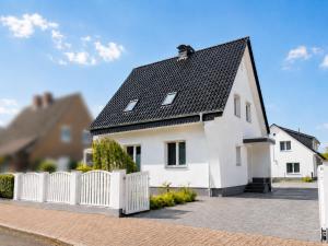 a white house with a black roof at Heidetraum - Modernes Ferienhaus in der Lüneburger Heide in Soltau