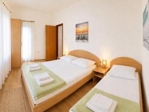 a bedroom with two beds and a window at Apartments Mohar III in Baška