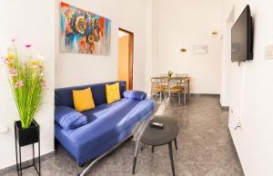 a living room with a blue couch and a table at Apartments Mohar III in Baška