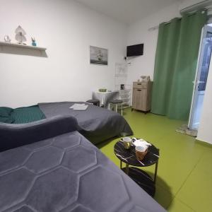 a room with two beds and a couch and a table at Sky Apartments Petrovac in Petrovac na Moru