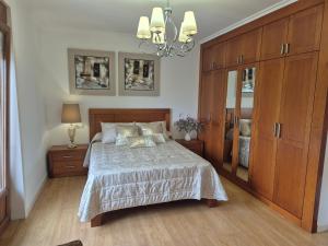a bedroom with a bed and a large wooden cabinet at Casa da Xoiña in Foz +38 photos