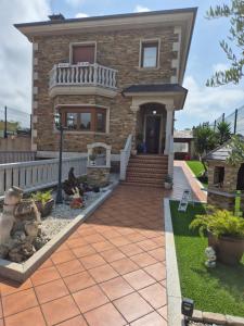 a brick house with a porch and a walkway at Casa da Xoiña in Foz