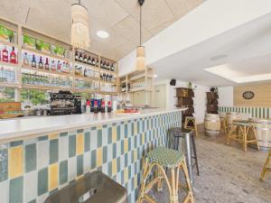 a kitchen with a bar with stools at Le Mid-Length- studio pour 3 - piscine commune in Biscarrosse +21 photos