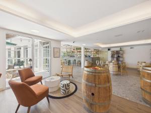 a room with cognac chairs and a barrel at Le Mid-Length- studio pour 3 - piscine commune in Biscarrosse