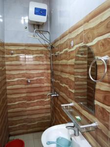 a bathroom with a shower with a sink and a mirror at Clover Apartments and suites in Abuja