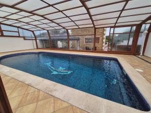 an indoor swimming pool with an open roof at Casa da Xoiña in Foz