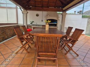 a wooden table and chairs on a patio with a fireplace at Casa da Xoiña in Foz