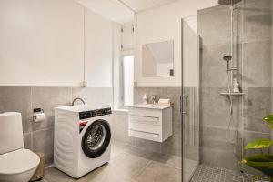 a bathroom with a washing machine and a shower at Bergen Guesthouse in Bergen +36 photos