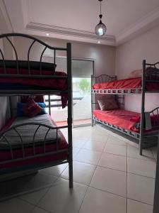 a room with two bunk beds and a window at Garden Beach 2 in Sidi Rahal +15 photos