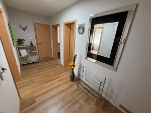 a hallway with a mirror and a vase with a flower at CAL Apartments in Duisburg