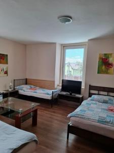 a room with two beds and a flat screen tv at Privát Čujová in Hrabušice +20 photos