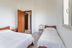 a bedroom with two beds and a chair at House&Villas - Residence Miramare in Avola