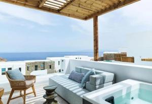 a patio with a couch and a table and chairs at LYO II Boutique Suites in Mikonos