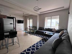 a living room with a couch and a tv at Garden Beach 2 in Sidi Rahal