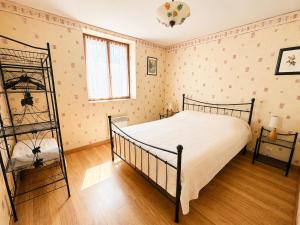 a bedroom with a bed with a white bedspread at Le petit Chai in Chémery