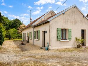 an old white building with green shutters on it at Le petit Chai in Chémery