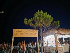 a man standing next to a sign at a beach at ARBERs aparthotel in Durrës