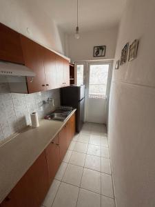 a kitchen with a sink and a refrigerator at Pieria Paralia Apartment in Paralia Katerinis