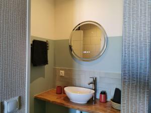 a bathroom with a white sink and a mirror at Fleurs et Abeilles in Faye-lʼAbbesse