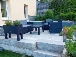 a patio with chairs and tables in a garden at Ferienwohnung mit Garten und Spielplatz in Klingenthal