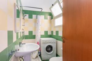 a bathroom with a washing machine and a sink at House&Villas - Residence Miramare in Avola