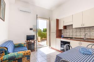 a kitchen with a couch and a table in a room at House&Villas - Residence Miramare in Avola