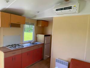 a kitchen with red cabinets and a sink and a window at Chez Elisa et Fabien in Canet-de-Salars