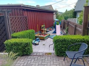 a backyard with a fence and a playground at Ferienwohnung mit Garten und Spielplatz in Klingenthal